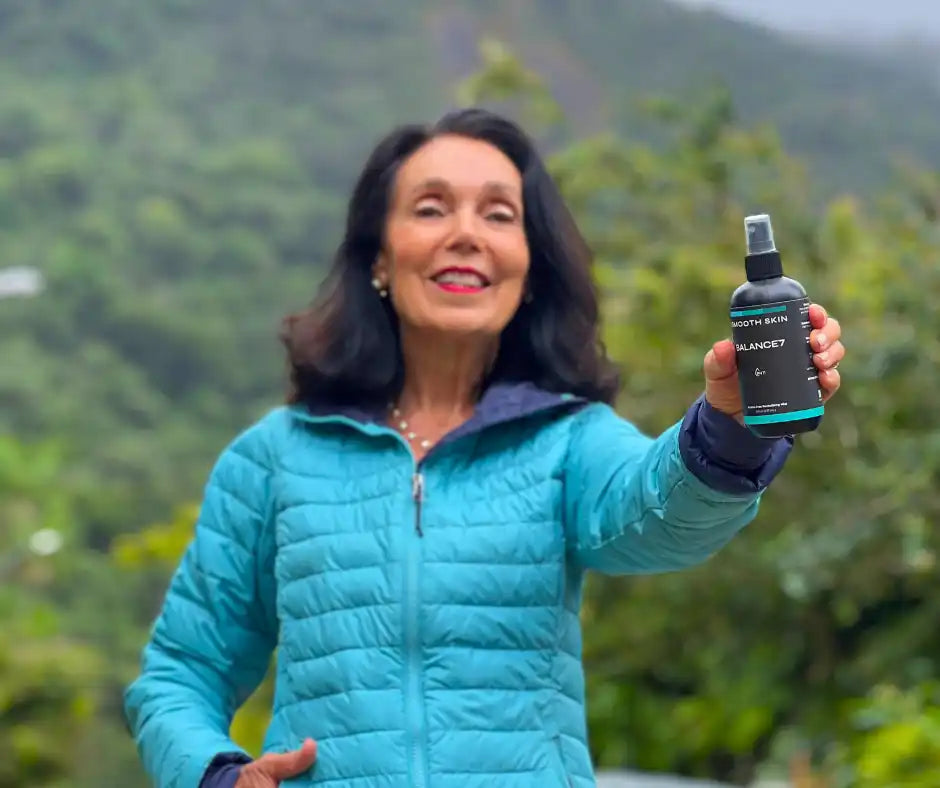 A woman in a blue jacket holding a black spray bottle.